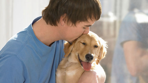 Un uomo bacia il suo cane